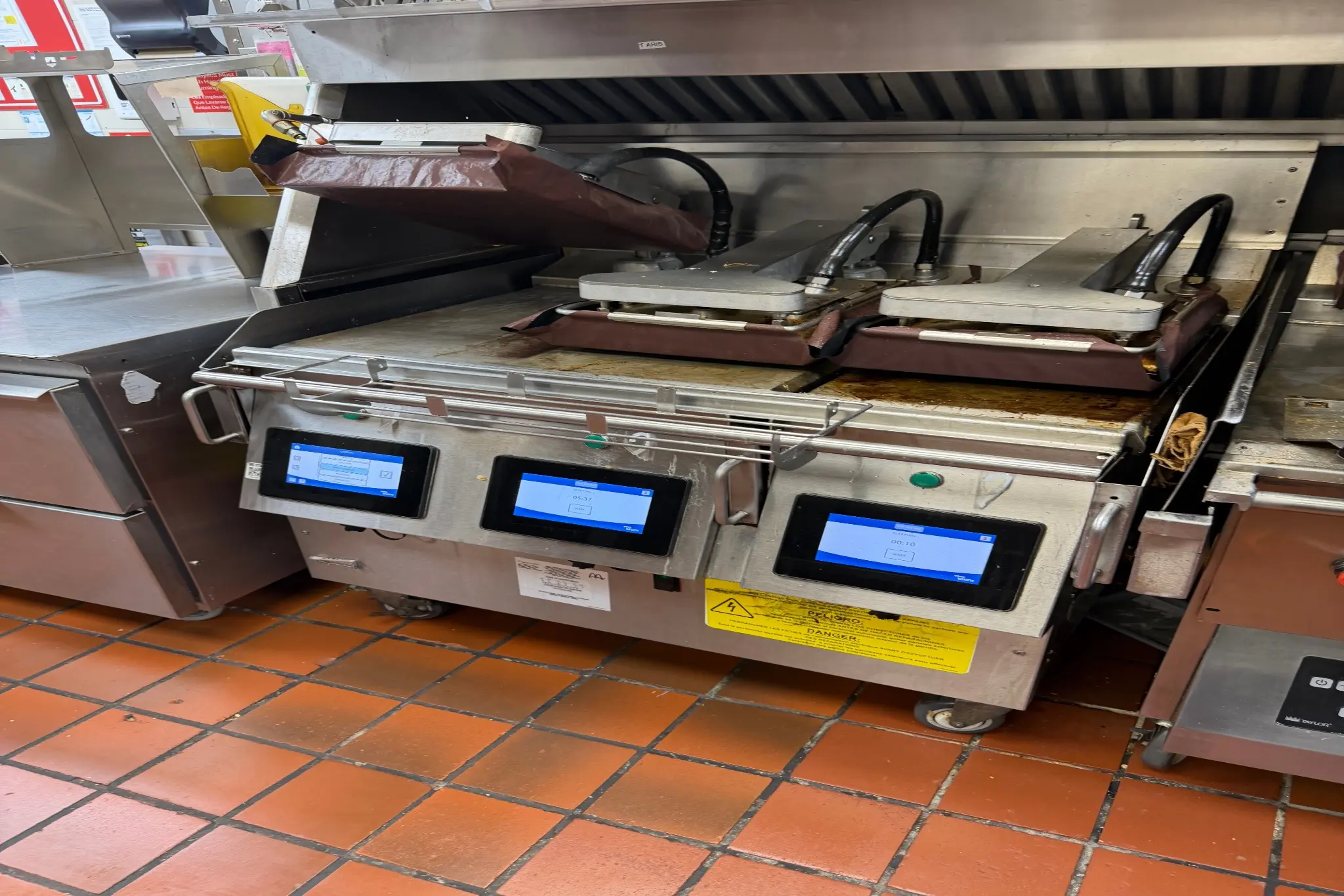 Commercial panini press in a restaurant kitchen.