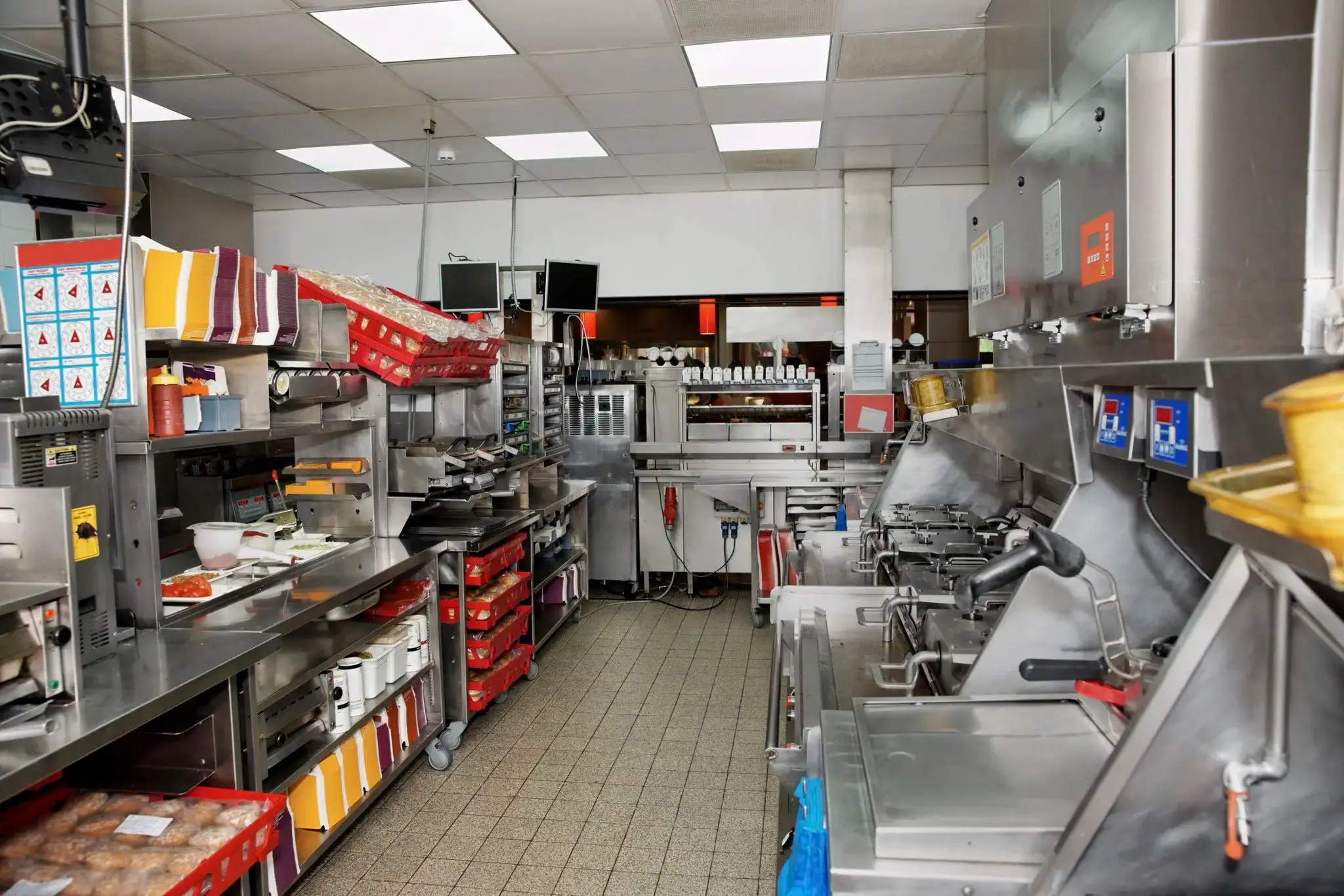Clean, well-organized commercial kitchen with stainless steel appliances and ample workspace.